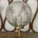 Small handcrafted globe lamp with a cracked finish and a golden brass base.