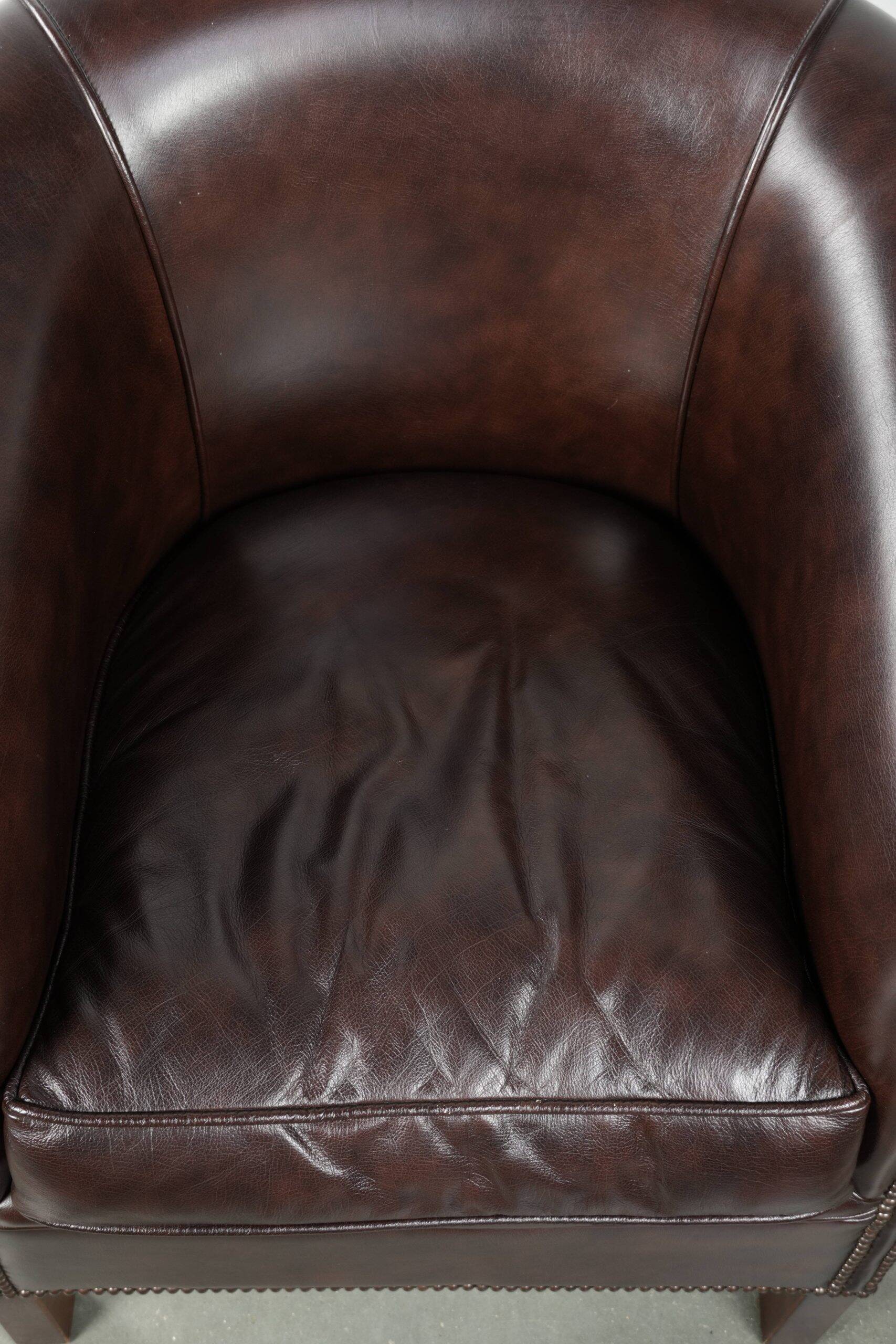 Dark cow leather club armchair with a stylish design in English style