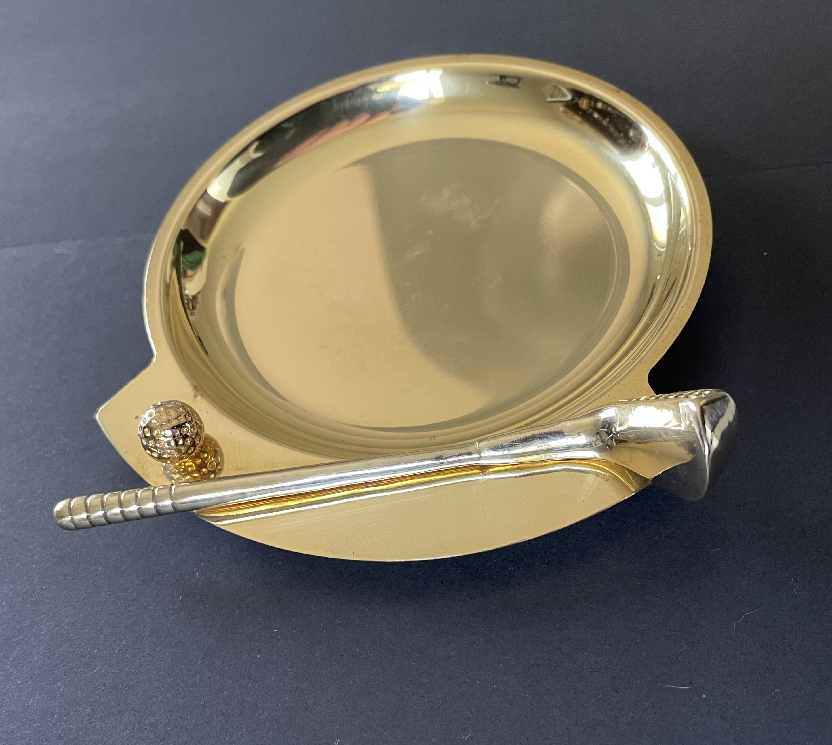 Round brass pocket tray with club and golf ball decoration.