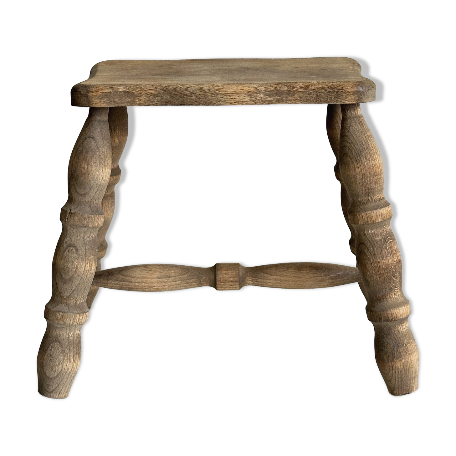 Antique wooden stool with four turned legs.