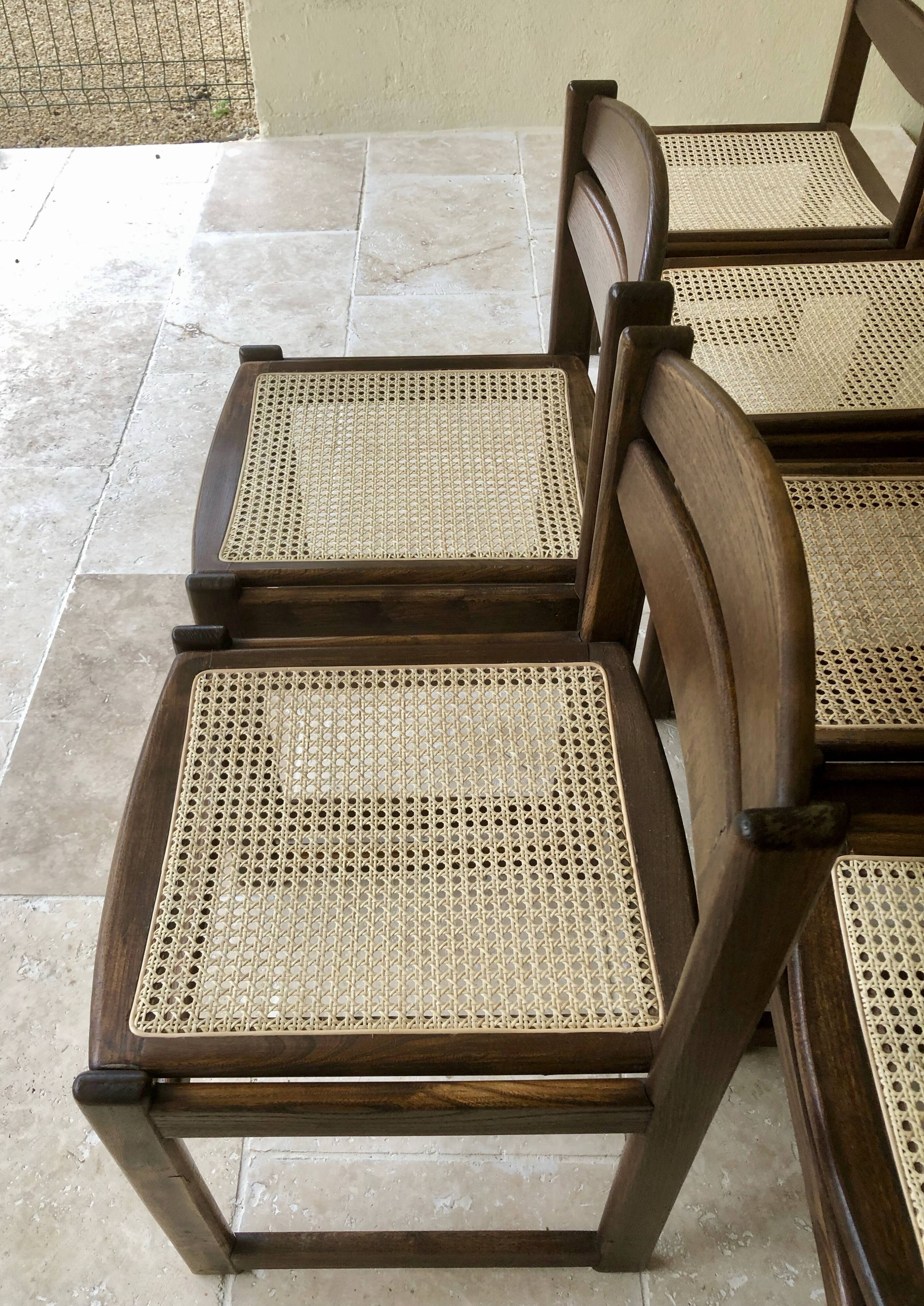 Set of 12 "sledge" dining chairs in walnut and cane.