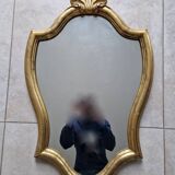 Carved and gilded wooden mirror, the pediment decorated with a shell.