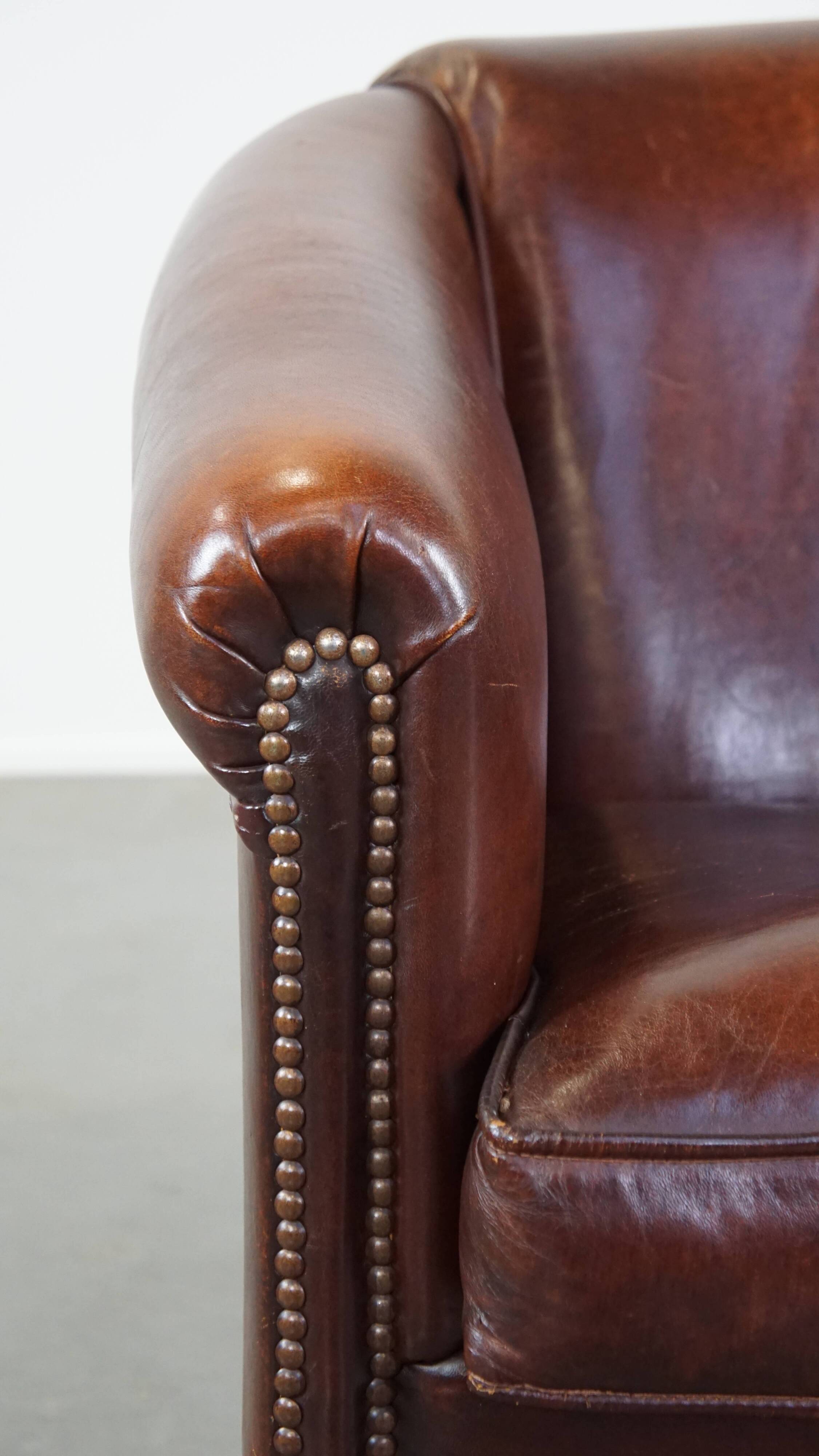 Sheepskin club armchair, correct finishing with decorative nails