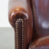 Sheepskin club armchair, correct finishing with decorative nails
