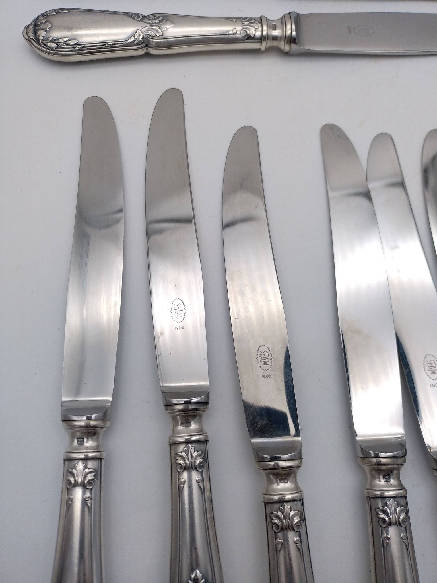 Set of 12 sfam knives in silver metal and stainless steel blades.