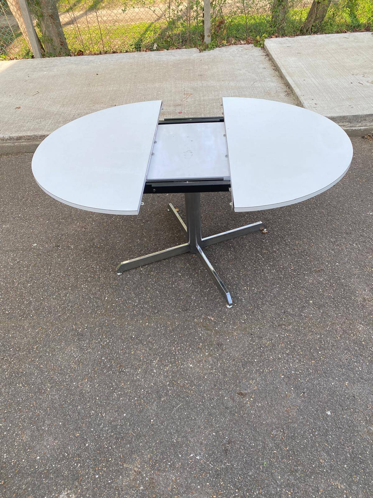 White dining table with a central pedestal, extendable, from the 1970s.