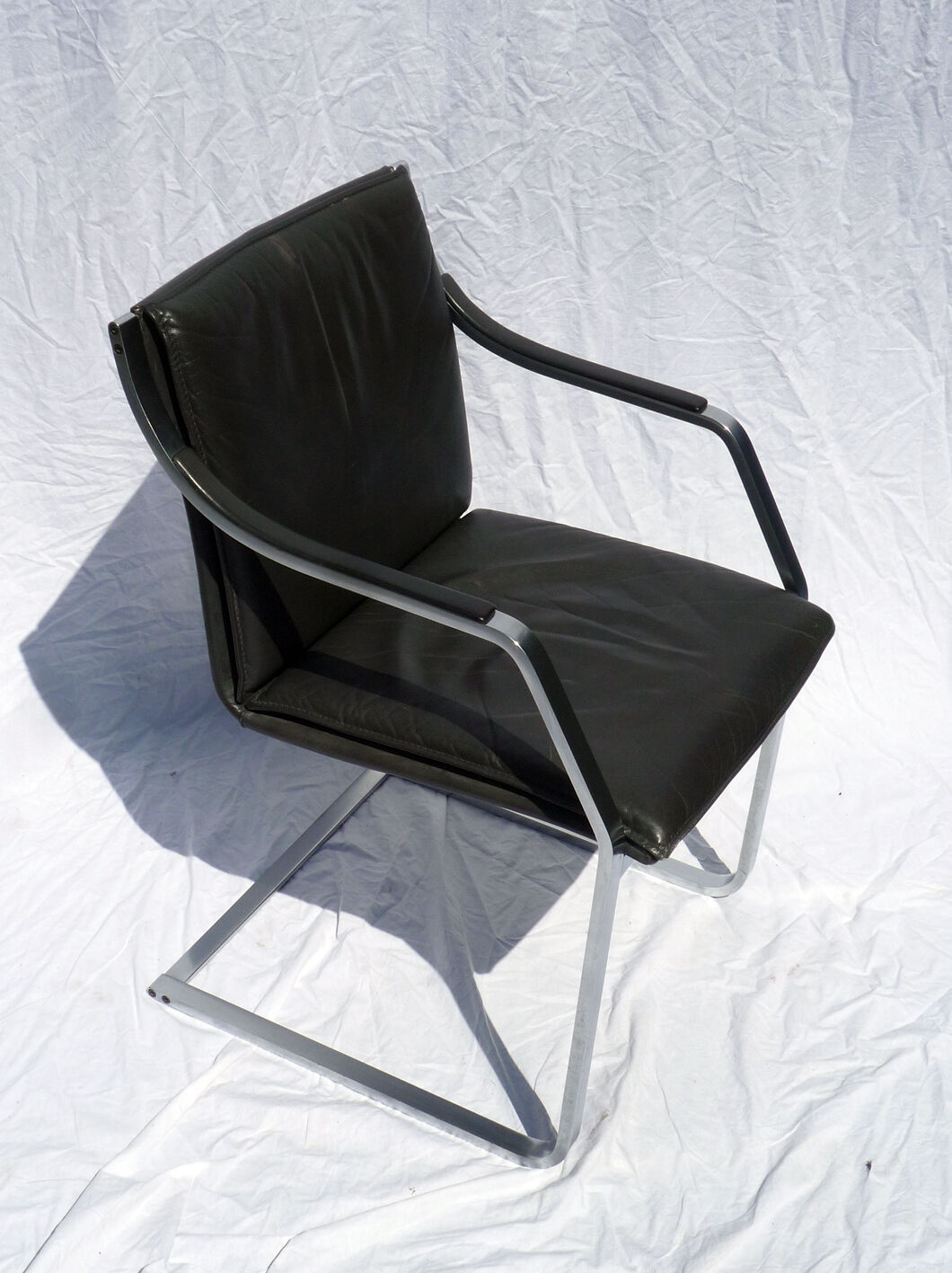 Chair with steel and leather armrests