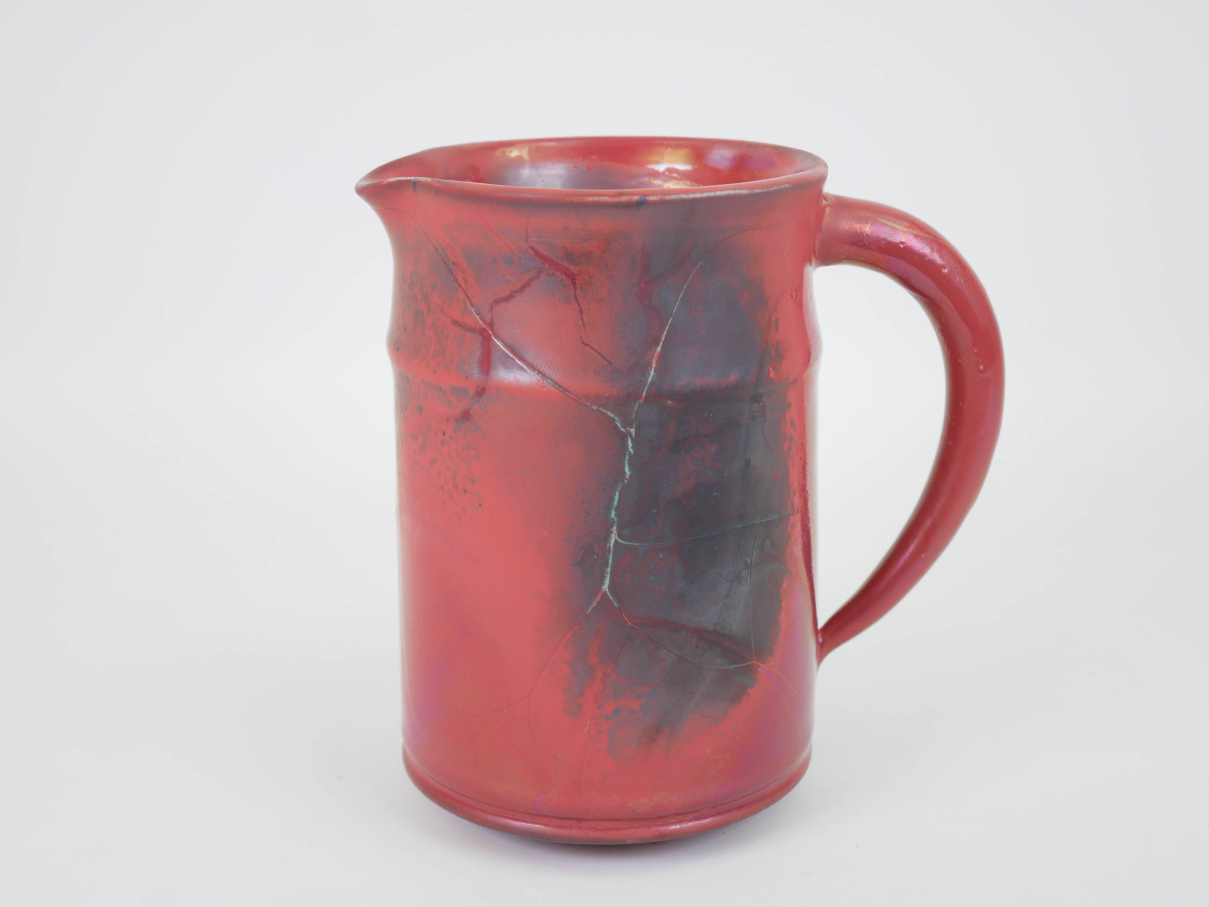 Red glazed ceramic jug with relief