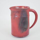 Red glazed ceramic jug with relief