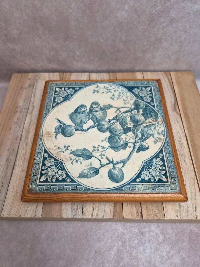 Antique trivet in Gien tile with blue bird decoration – wooden border