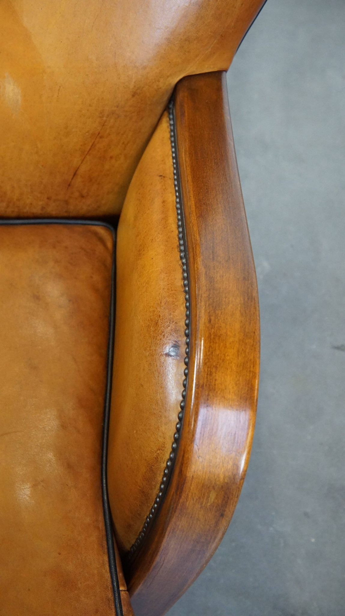 Unique, luxurious sheepskin armchair combined with wood and finished with decorative nails