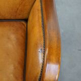 Unique, luxurious sheepskin armchair combined with wood and finished with decorative nails