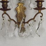 Pair of French antique brass double wall lights with assorted crystals.