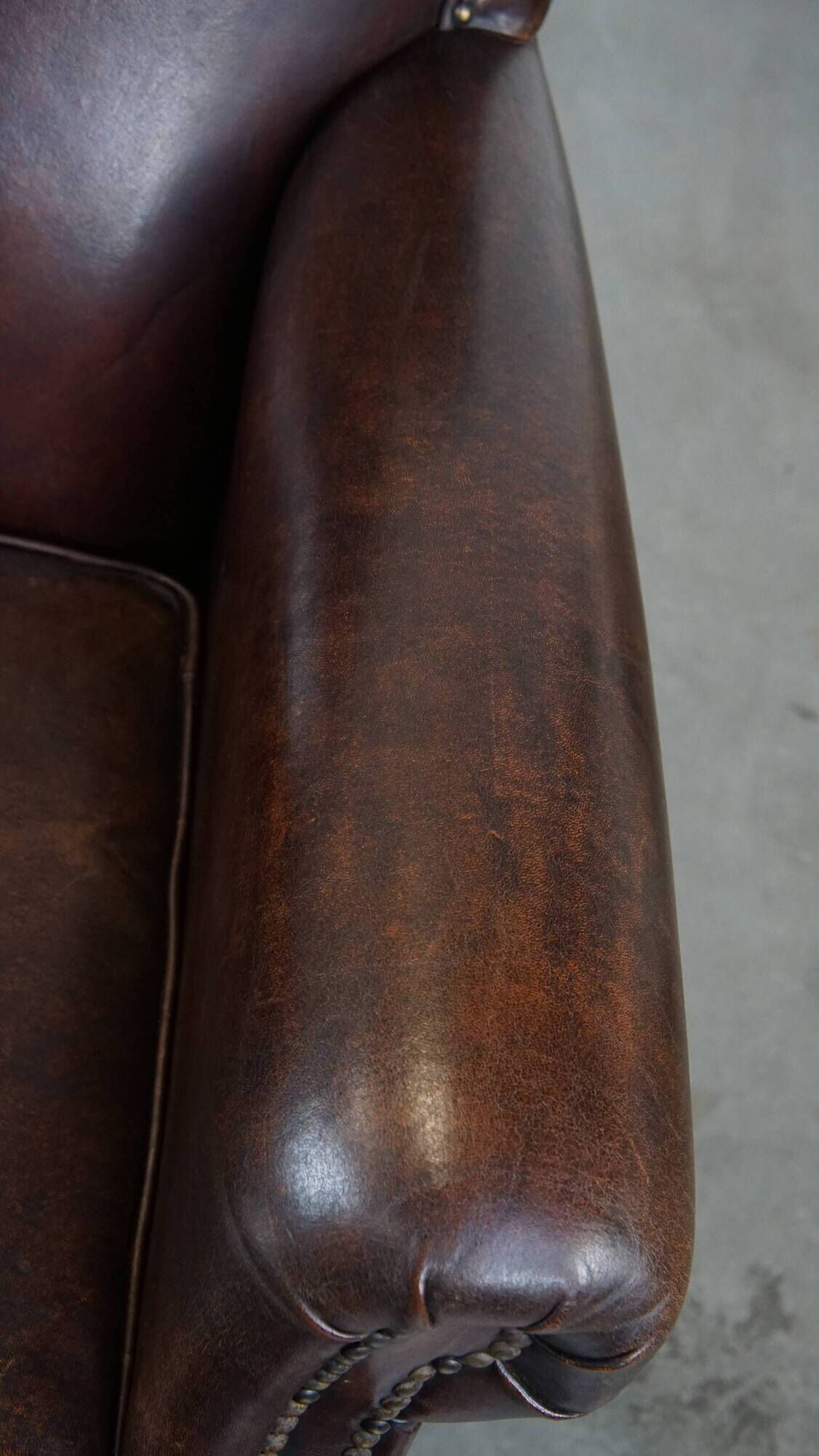 Dark brown sheepskin armchair finished with decorative nails