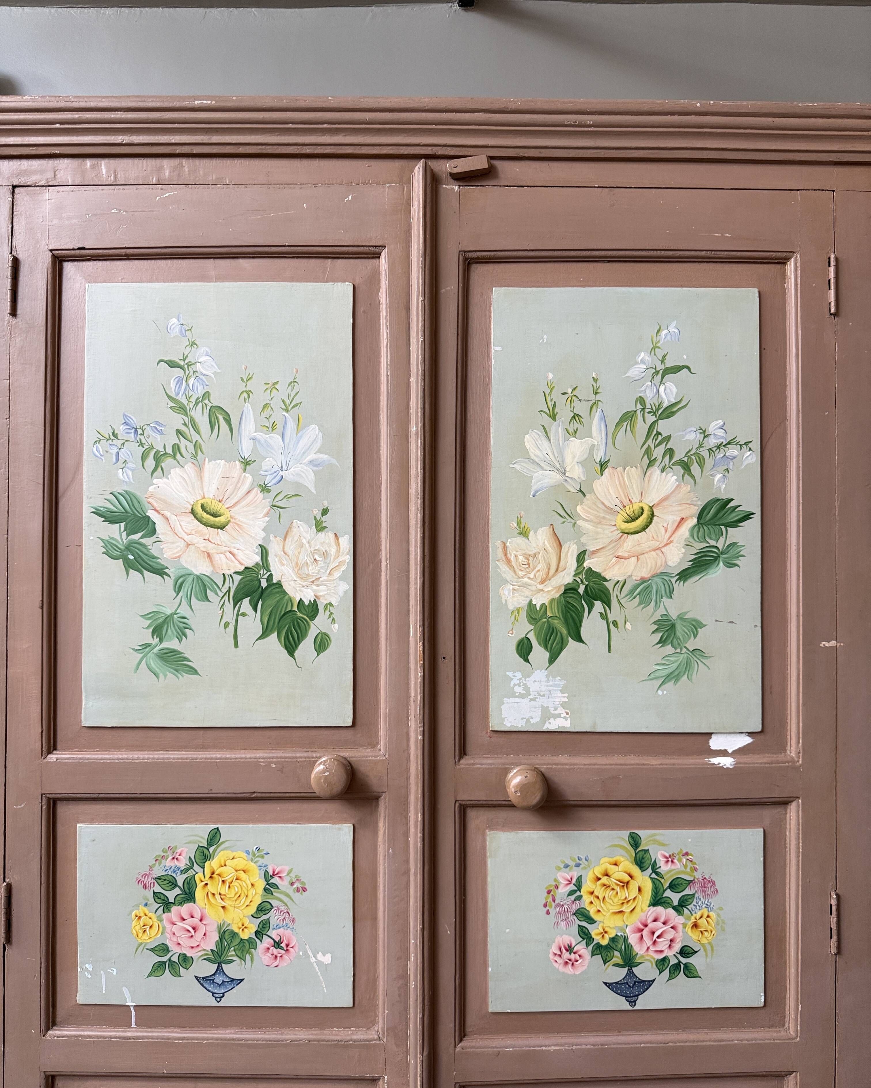 Large antique wardrobe painted with floral decoration.