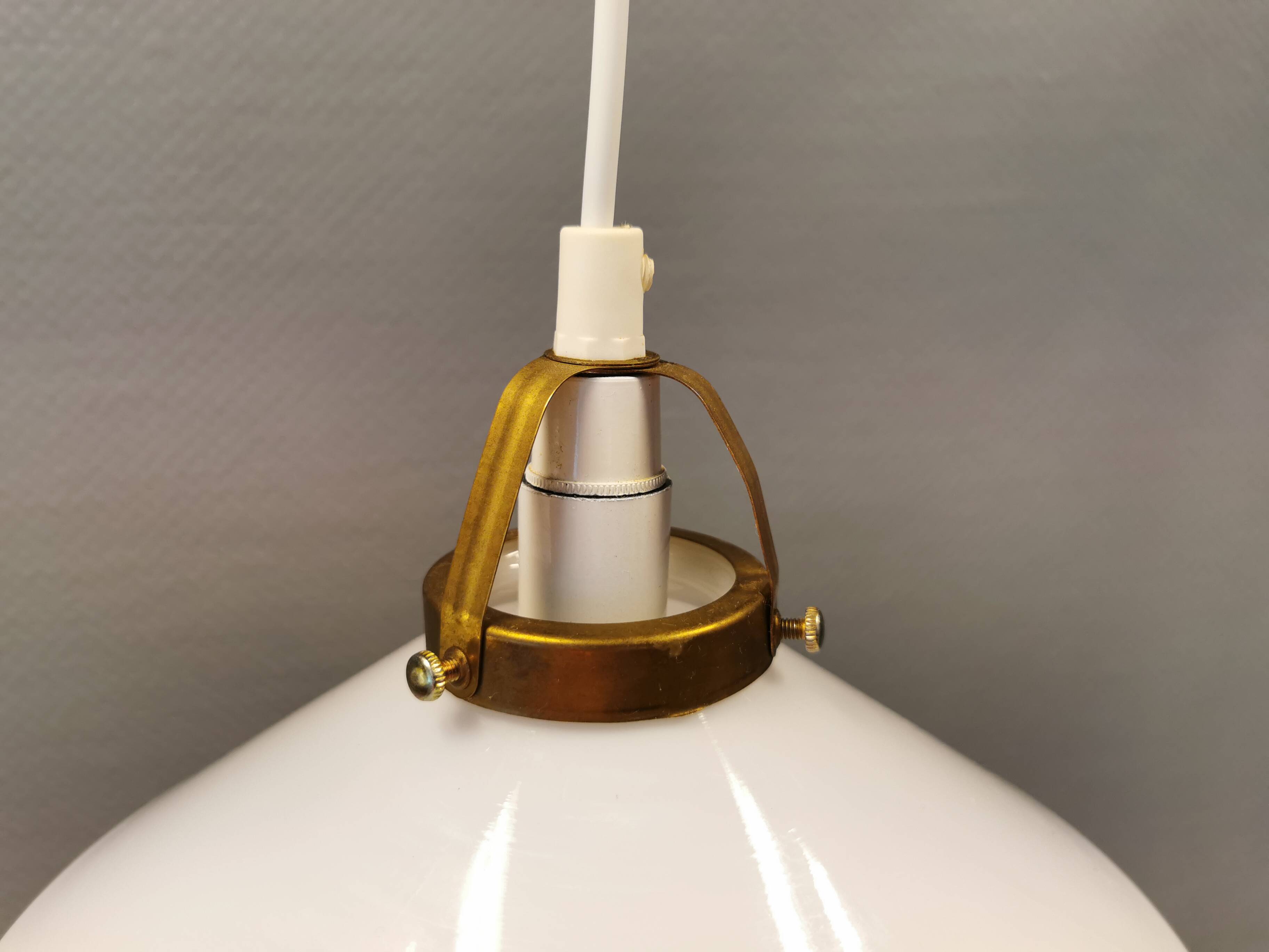 A set of hanging lamps in milky white opal glass with brass top.
