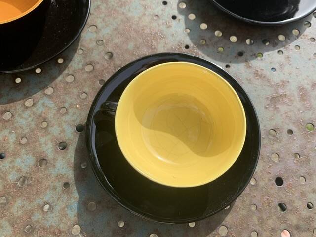 Coffee service composed of 5 cups and saucers in black earthenware and different colored interiors