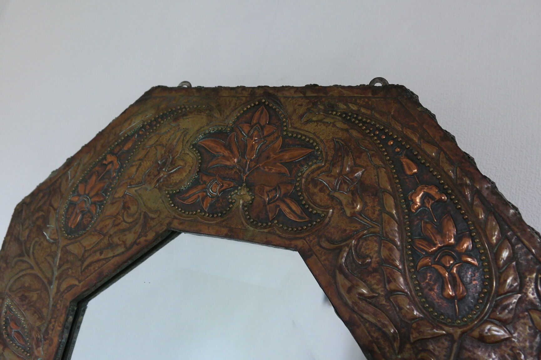 Antique bevelled artisanal mirror in repoussé copper - 54x45cm