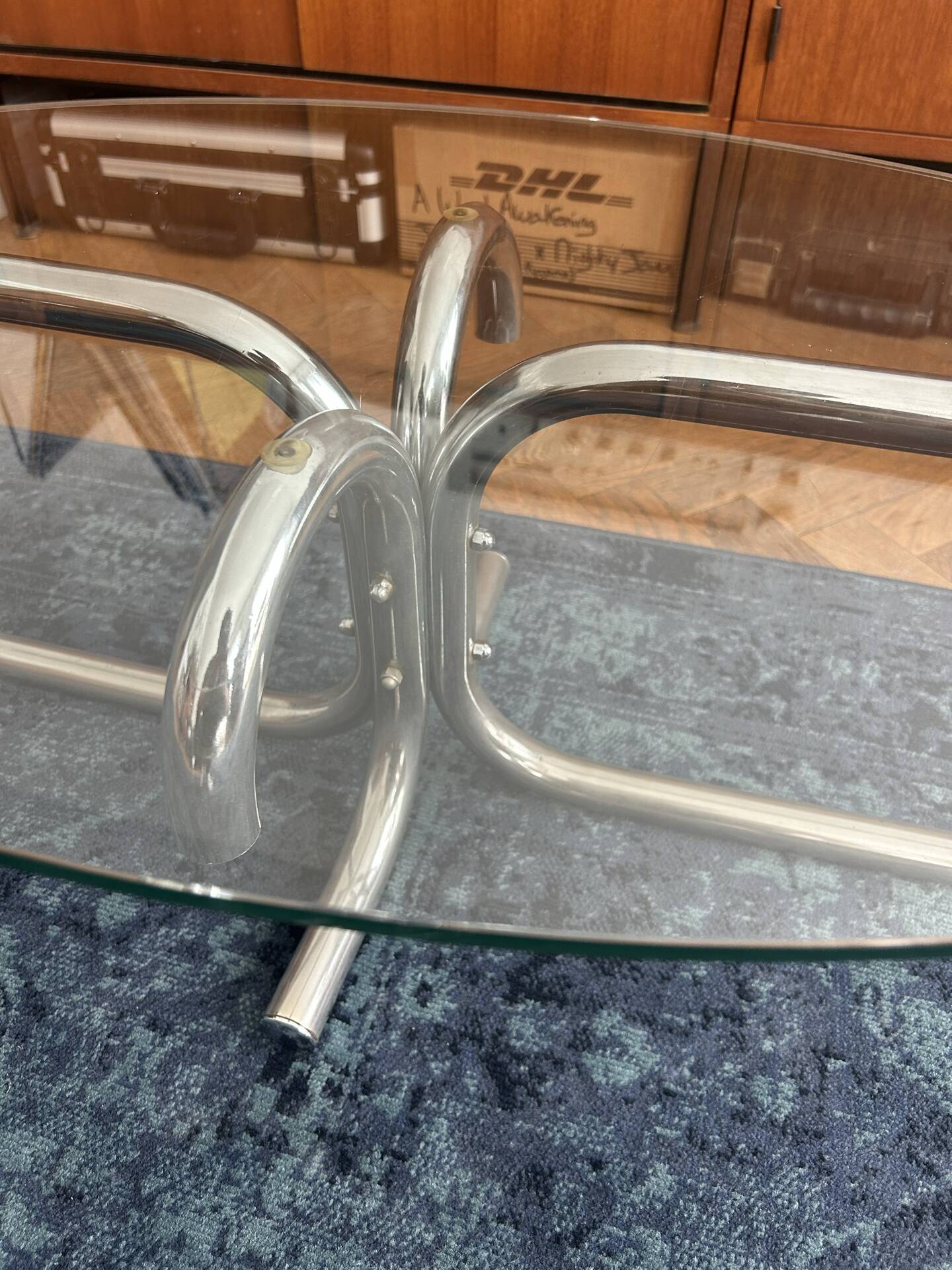 Oval glass coffee table with chrome legs, vintage 70s design.