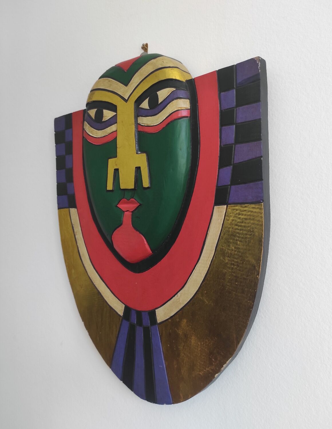 Handcrafted decorative wall mask made of painted wood.