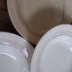 6 old cream-coloured deep plates with blue/orange trim.