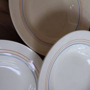 6 old cream-coloured deep plates with blue/orange trim.