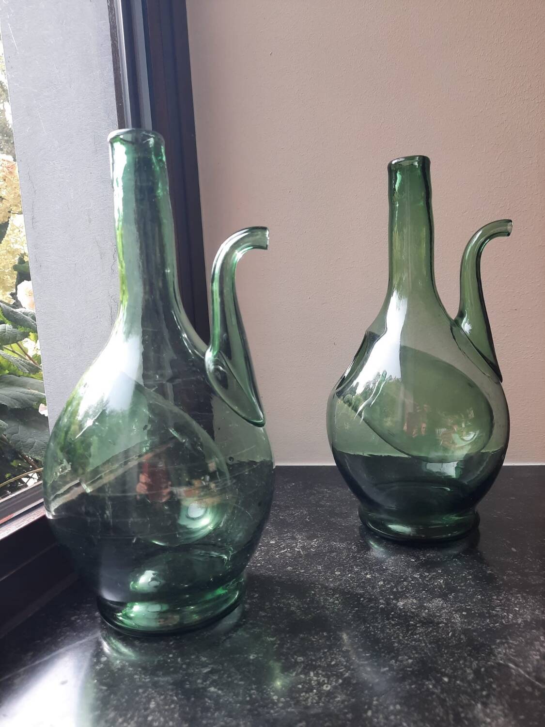 Pair of blown glass wine decanters in blue/green hues.