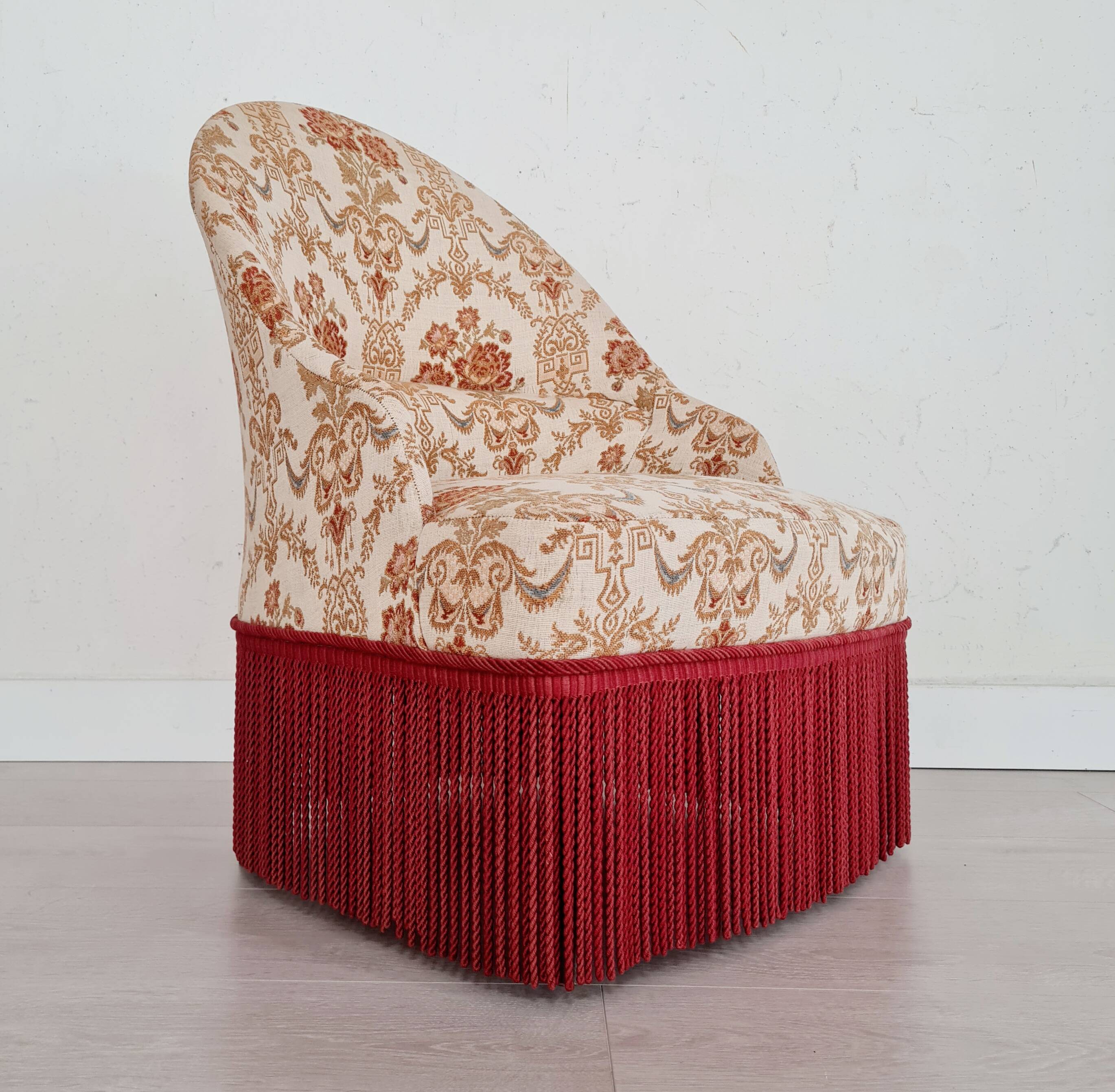 Beige toad armchair with floral patterns and red fringes