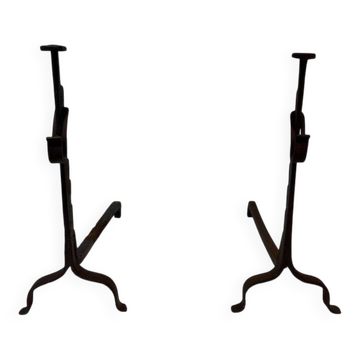 Pair of wrought iron andirons with adjustable supports and tripod feet.