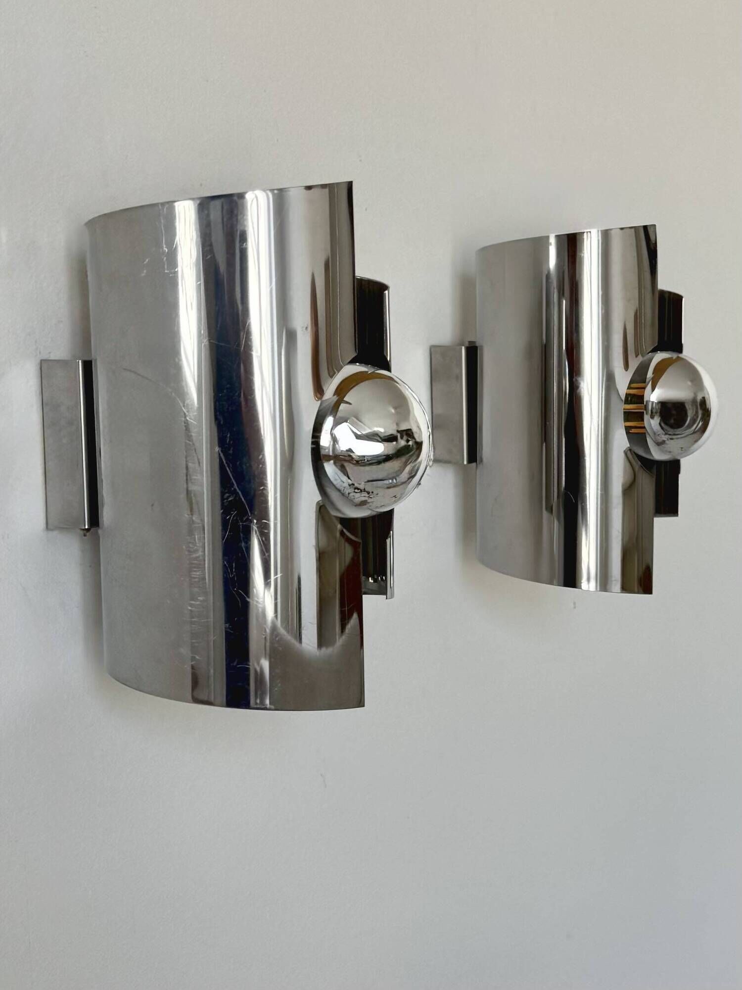 Pair of vintage wall lights, curved chrome metal, France, 1970.
