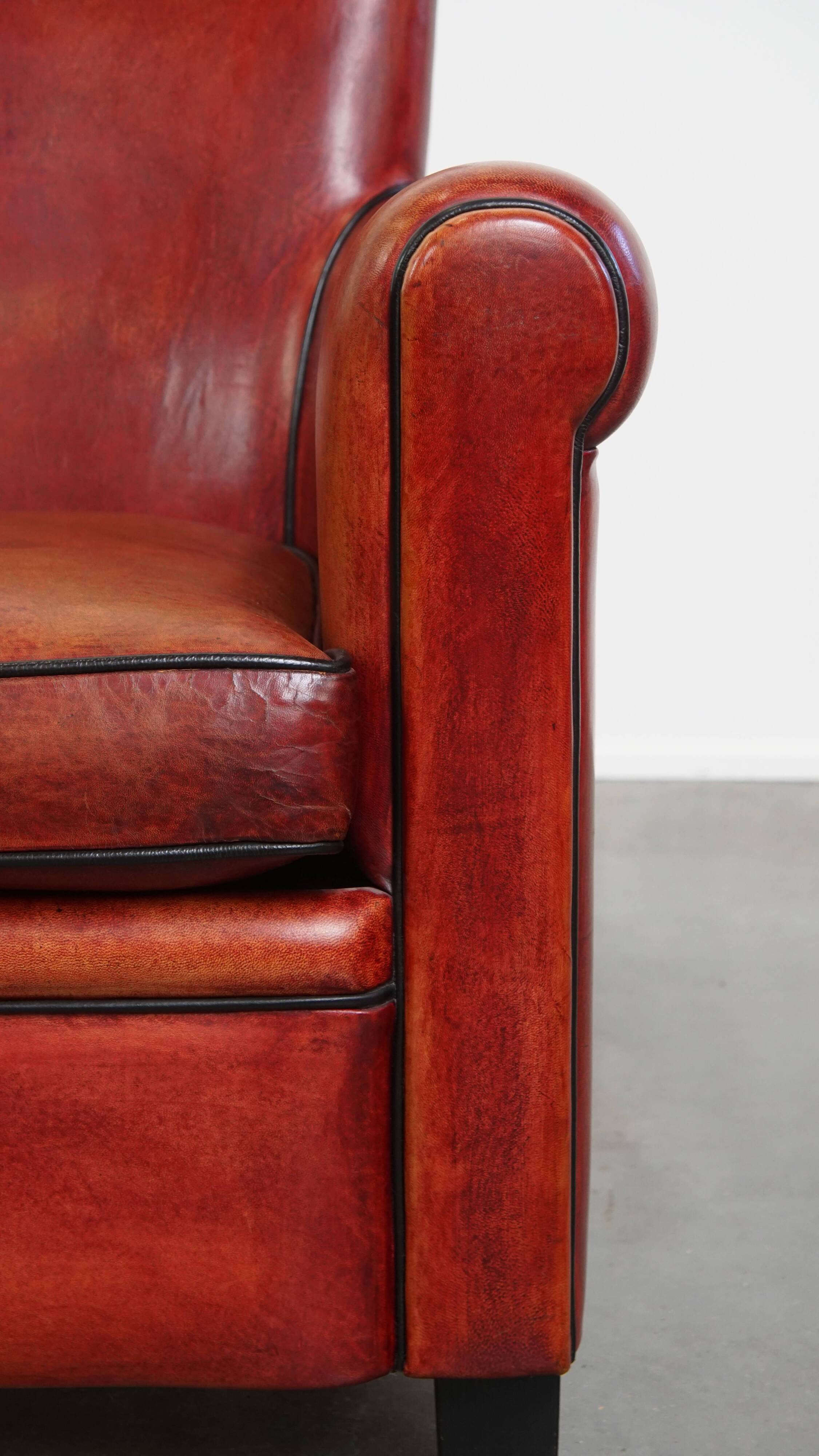 Armchair made of sheepskin leather in a red/brown color