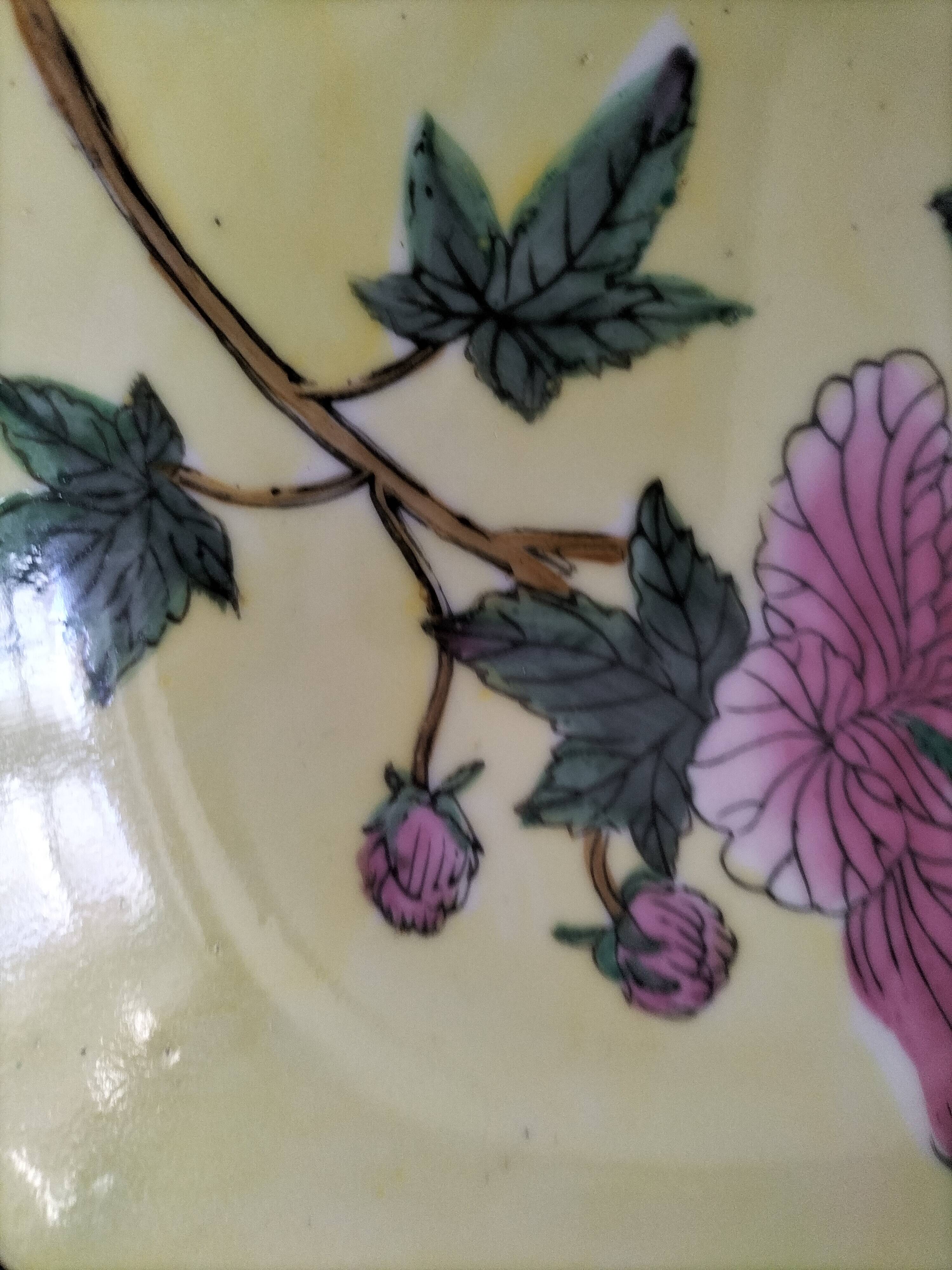 Pair of vintage Chinese decorative plates with floral decoration on a yellow background