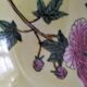 A pair of vintage Chinese decorative plates with floral designs on a yellow background.
