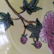 A pair of vintage Chinese decorative plates with floral designs on a yellow background.