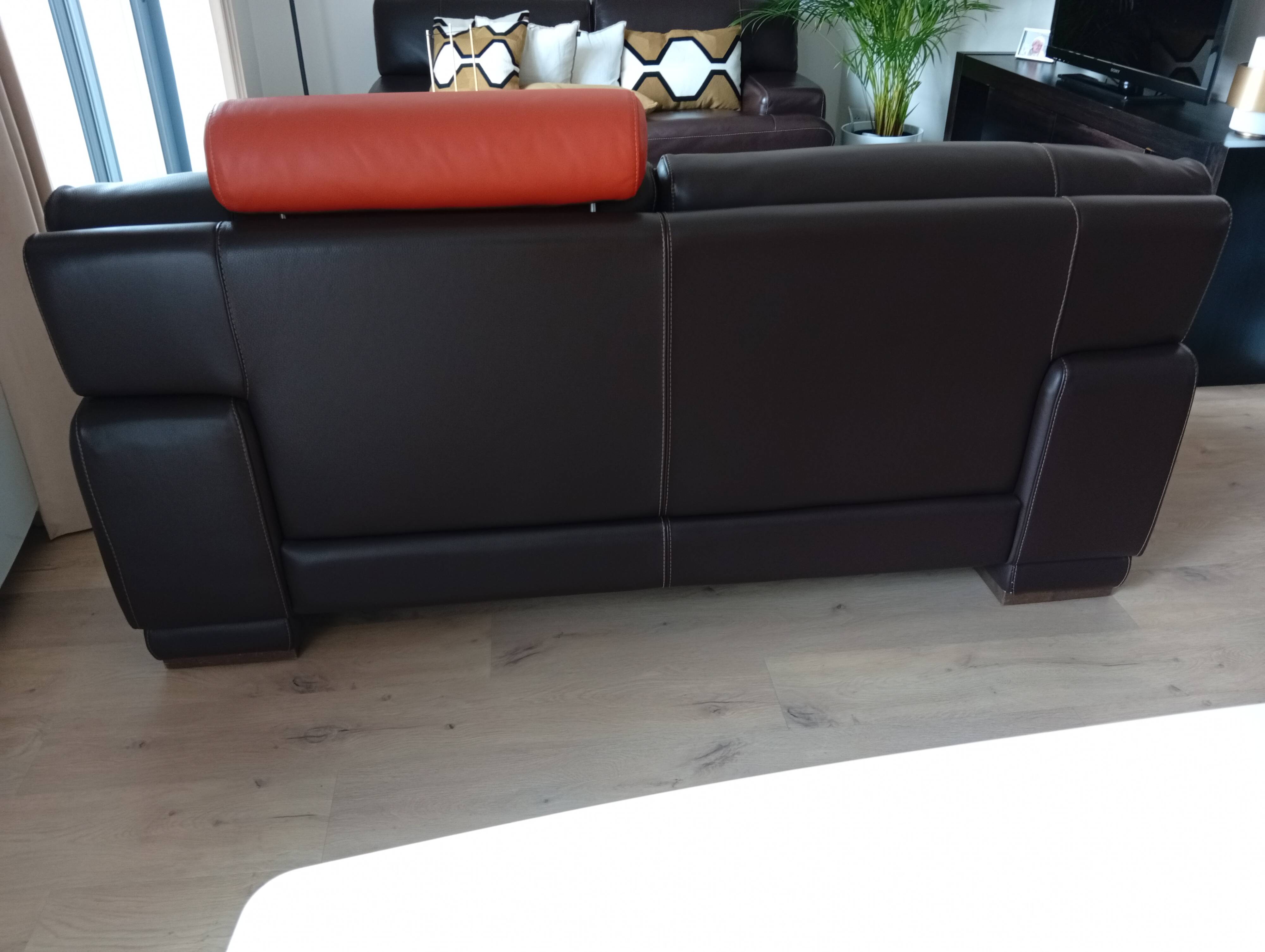 Two brown leather Crozatier two-and-a-half-seater sofas.