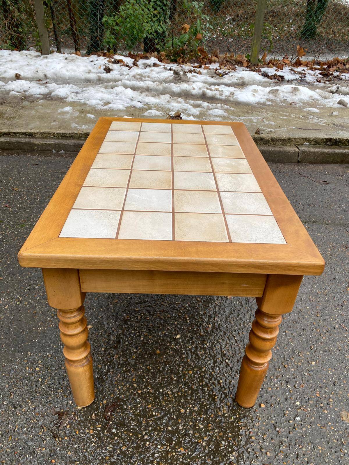 Light solid wood coffee table with tiles and a drawer.