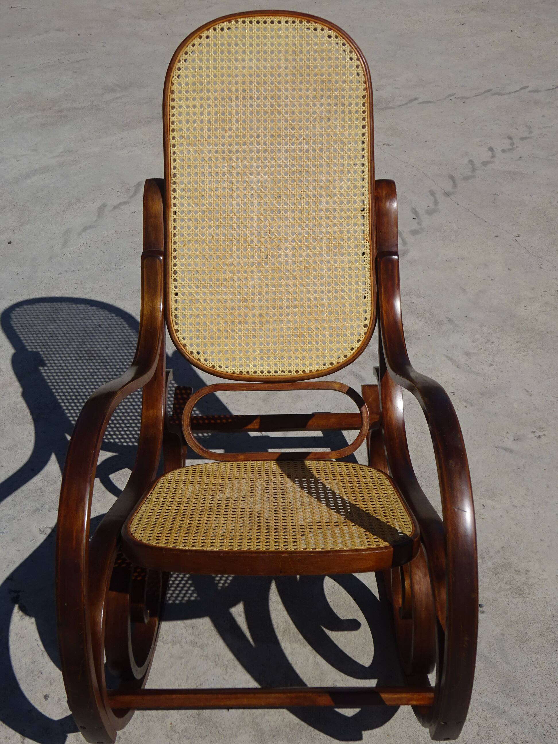 Vintage wooden rocking chair with caning