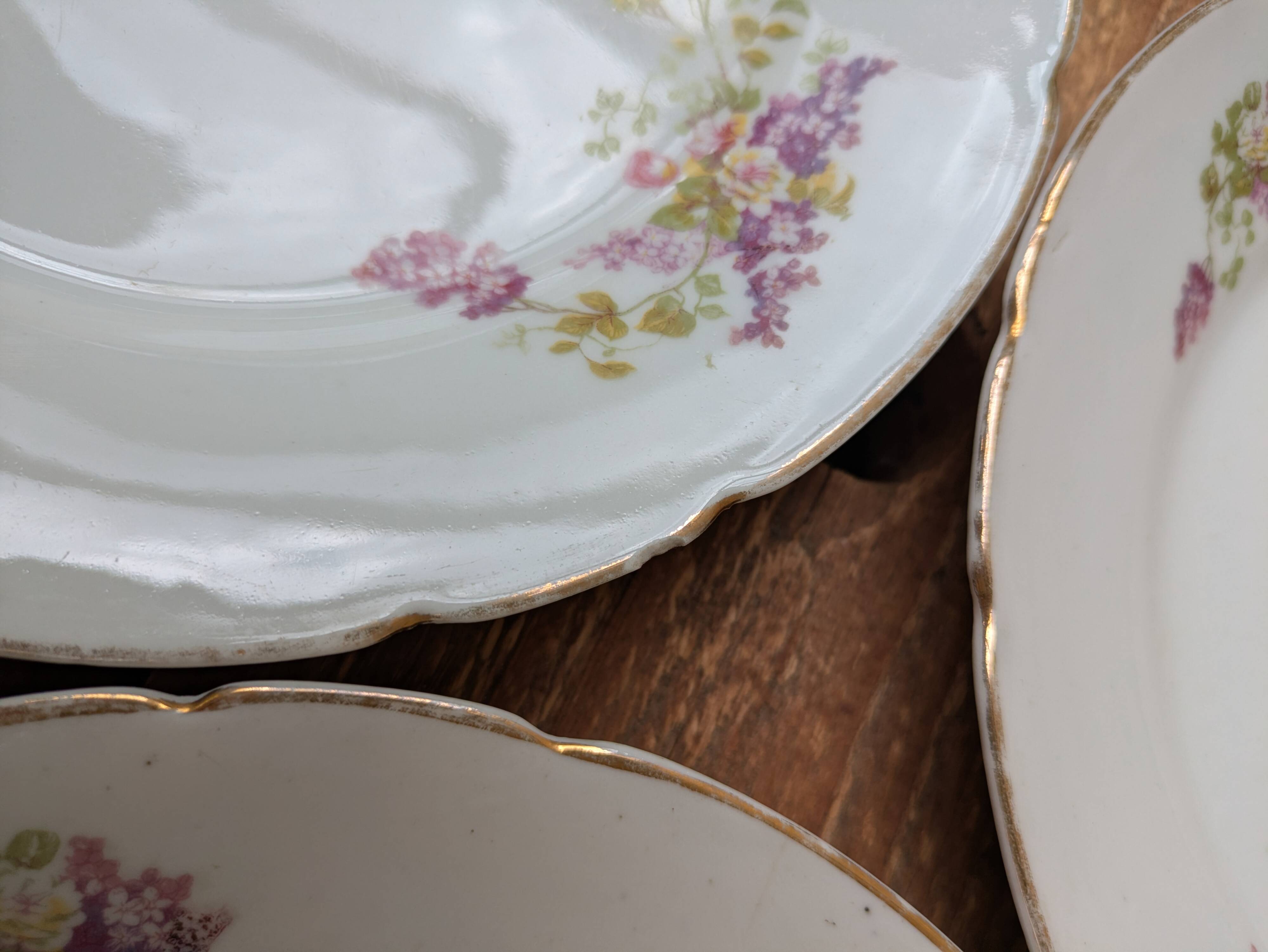 7 dessert plates in porcelain with a violet lilac design and a gold rim.