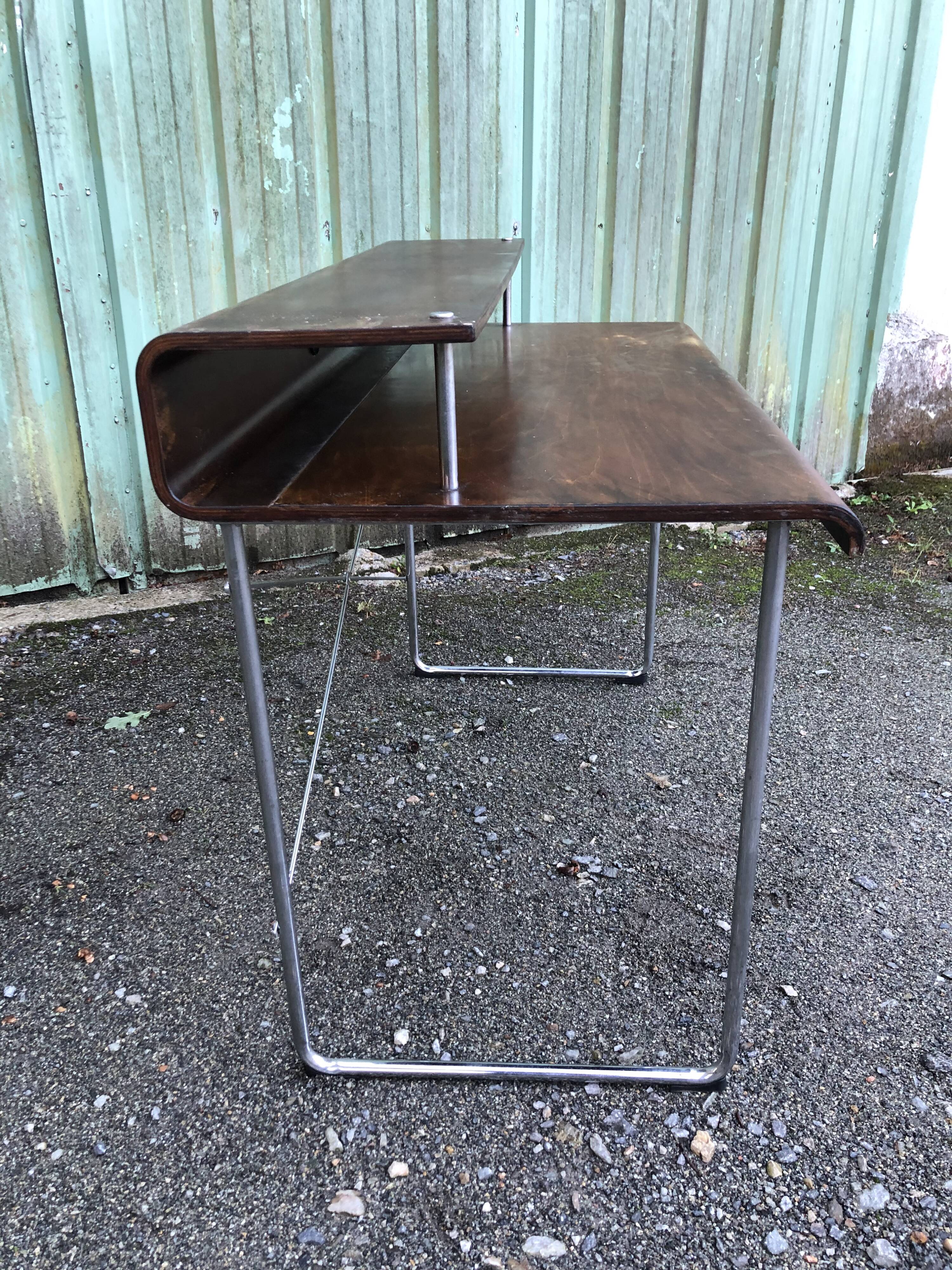 Design desk in formed glued laminated wood with chrome tubular base.
