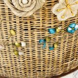 Vintage wicker mannequin with colourful floral decoration.