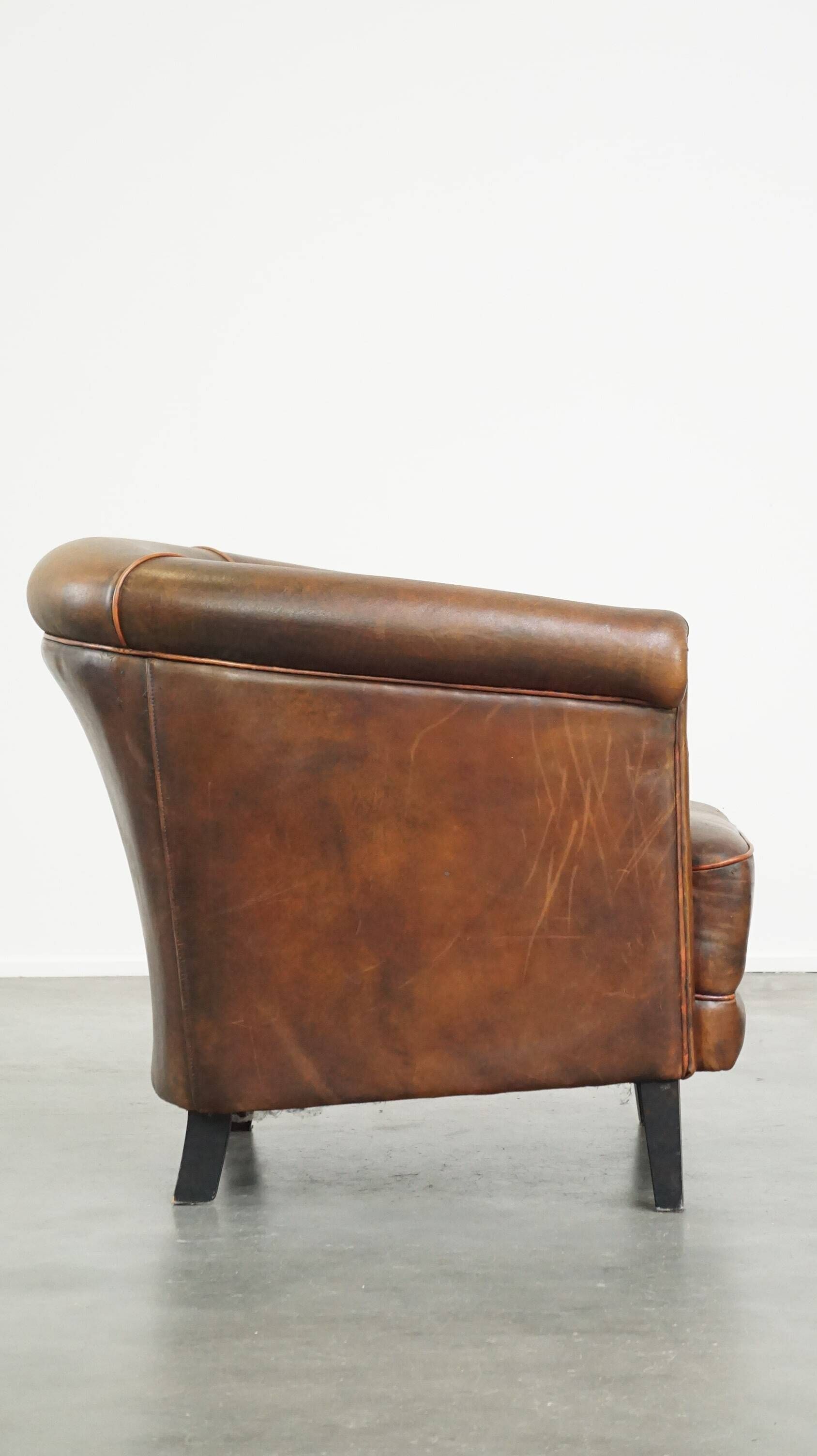 Neat, elegantly finished, cozy sheepskin club armchair with a fixed seat cushion