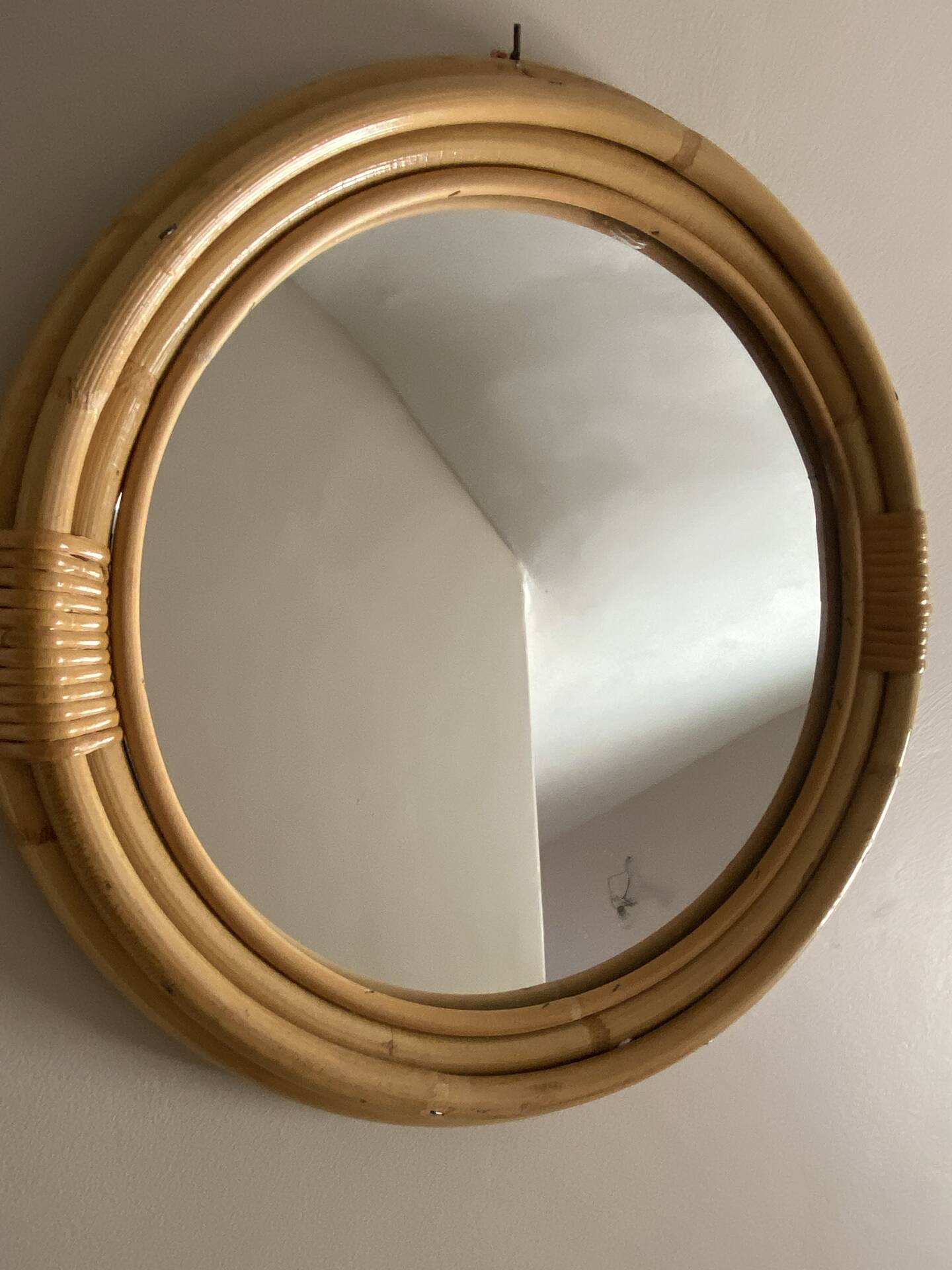 Round mirror from the 1960s with a frame made of rattan and metal.
