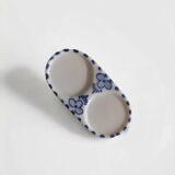 Mini salt and pepper shakers in ceramic with illustrations of Dutch windmills and blue flowers.