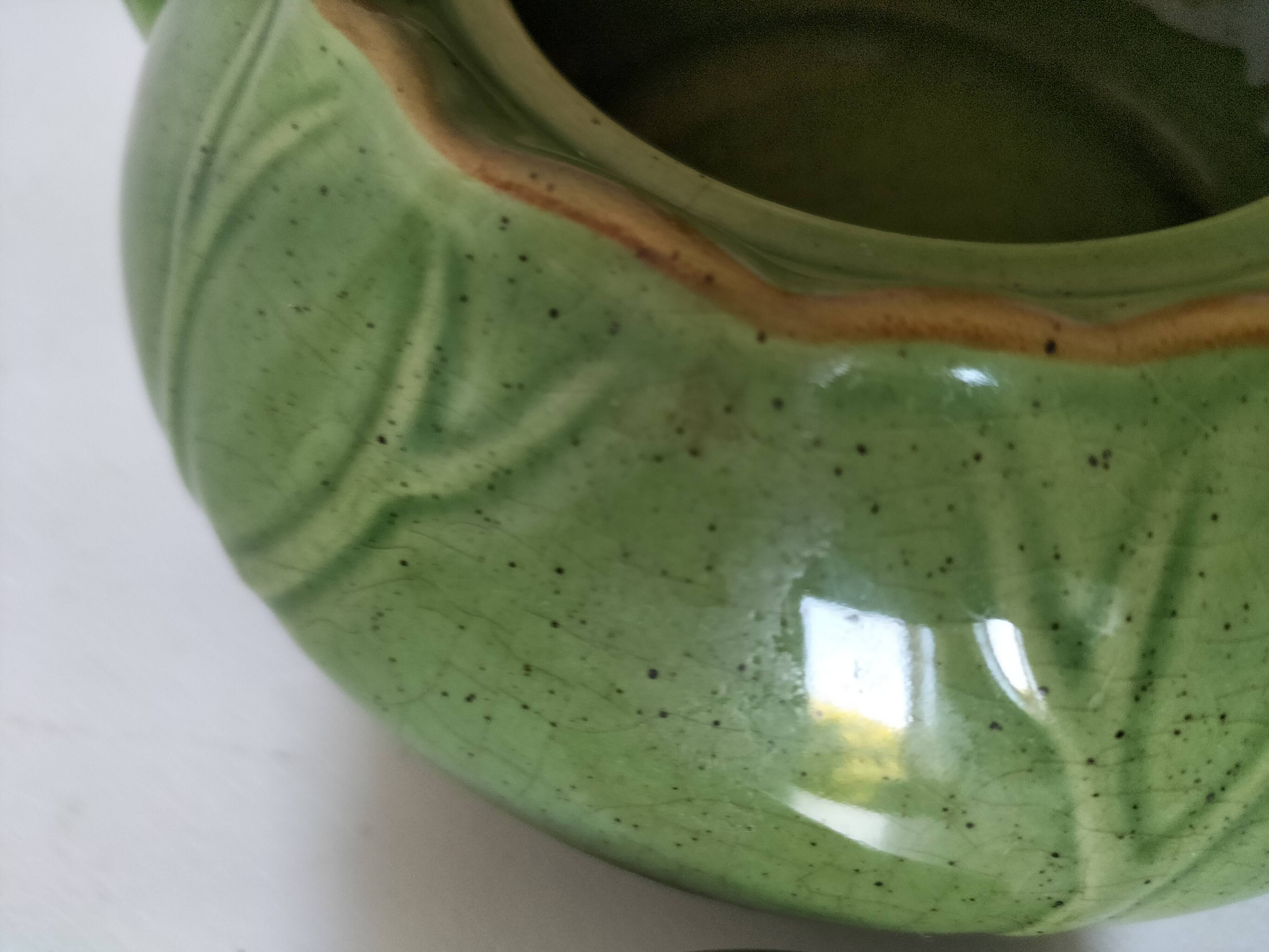 Vintage green teapot with lotus decoration and bamboo handle.