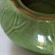 Vintage green teapot with lotus decoration and bamboo handle.