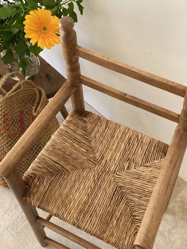 Ancienne chaise haute d’enfant en bois massif avec assise paillée.