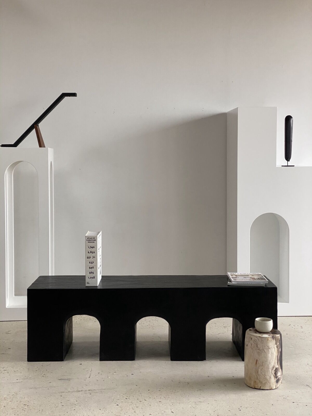 Black solid monoxyl wood bench carved into 3 arches