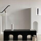 Black solid monoxyl wood bench carved into 3 arches