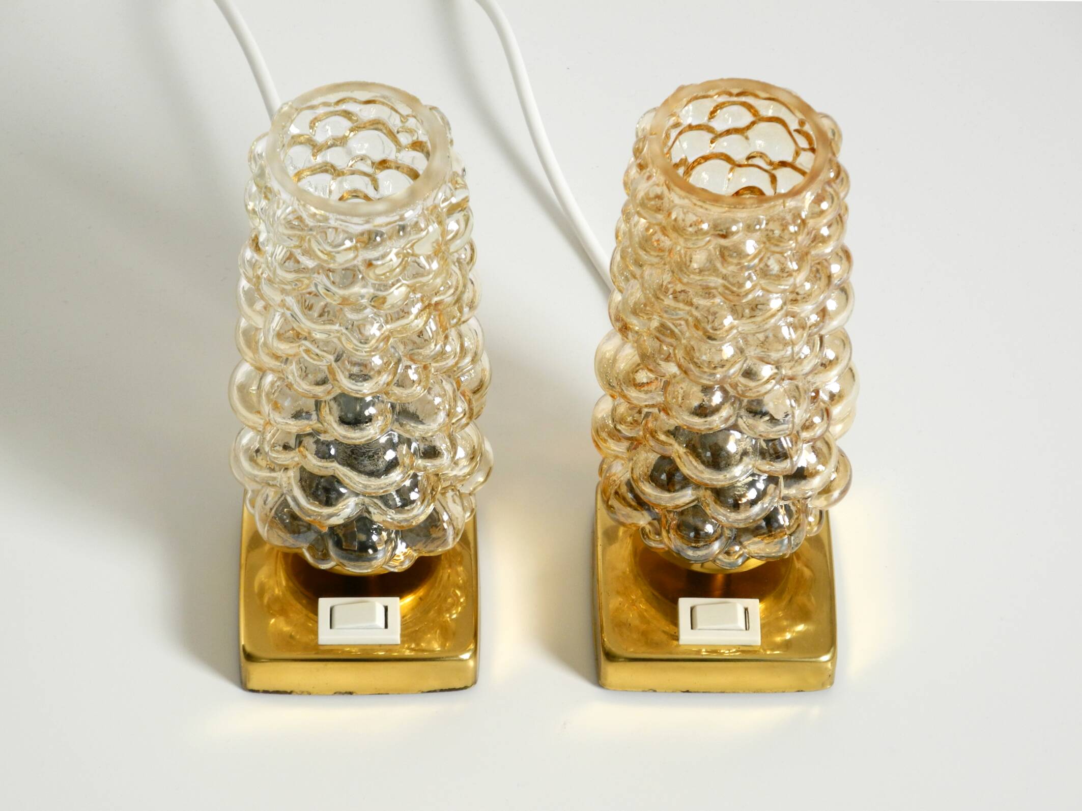 Deux lampes de chevet en laiton rares des années 1960 avec des abat-jours en verre bullé doré.
