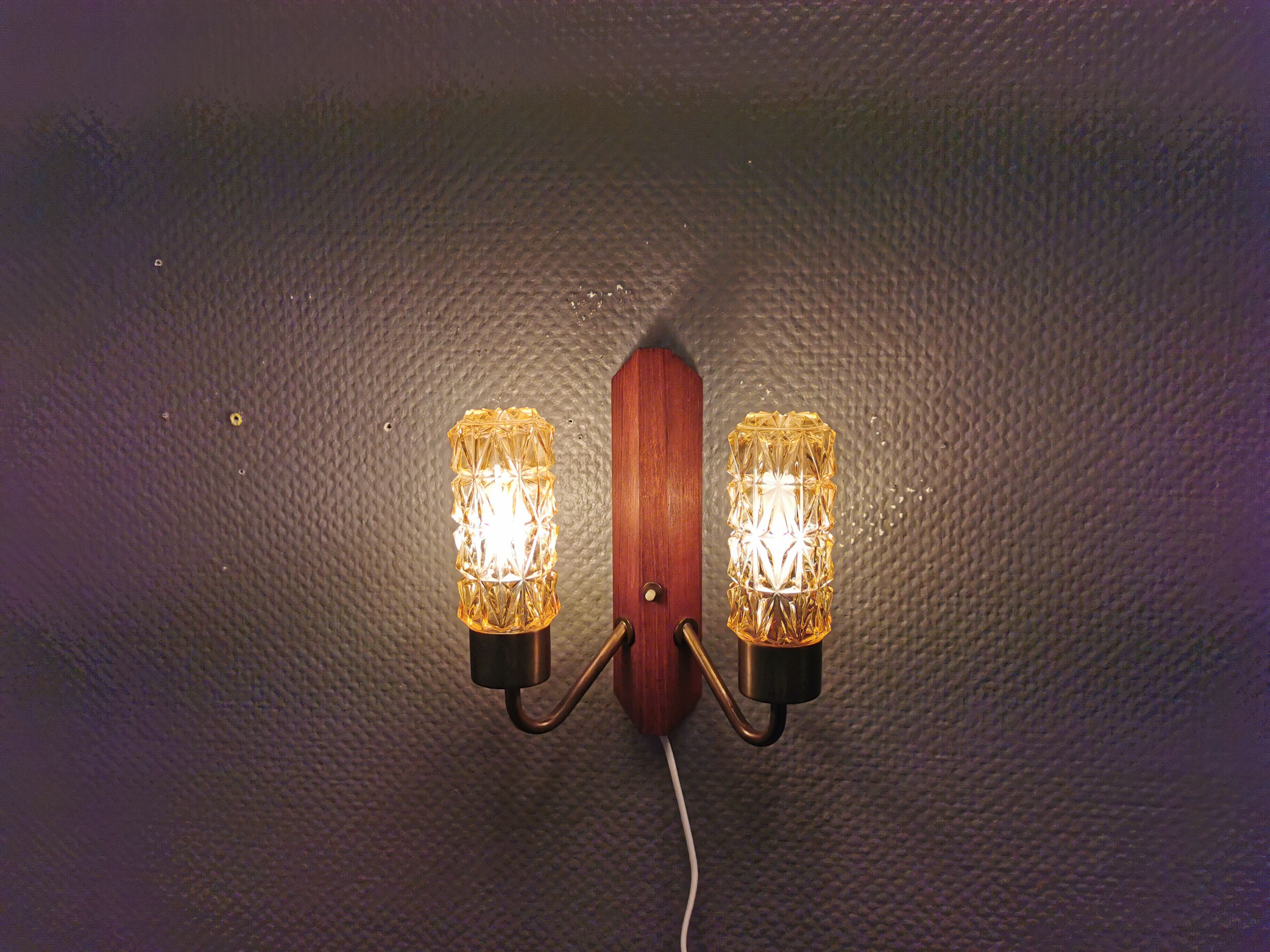 Older Danish wall lamp, with double light source, made of teak wood, amber colored glass and brass